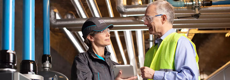 Atlas Copco Service Technikerin im Gespräch mit Kunde